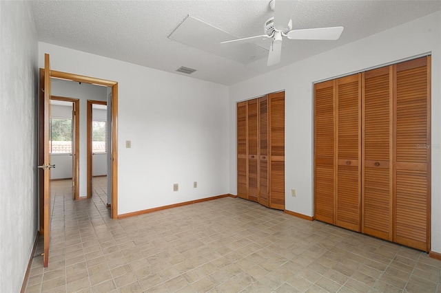 55 Village Cir, Palm Coast, FL 32164 - unfurnished bedroom with multiple closets, a textured ceiling, baseboards, and ceiling fan