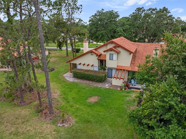 55 Village Cir, Palm Coast, FL 32164 - mediterranean / spanish-style home with a chimney, a tiled roof, stucco siding, and a front yard