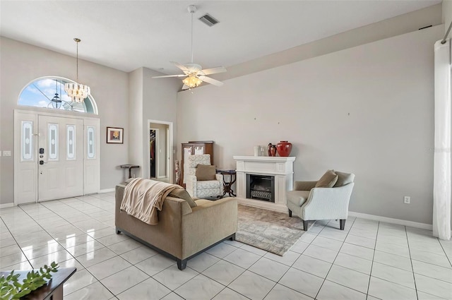 80 Flemingwood Ln, Palm Coast, FL 32137 - living area featuring light tile patterned floors, a glass covered fireplace, a chandelier, baseboards, and a towering ceiling