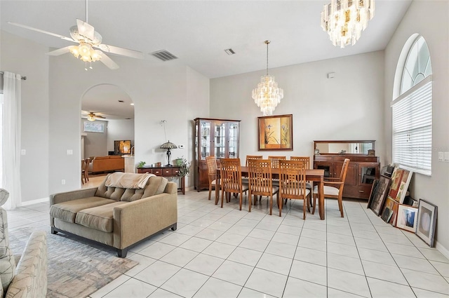 80 Flemingwood Ln, Palm Coast, FL 32137 - dining room with a ceiling fan, a chandelier, light tile patterned flooring, a high ceiling, and arched walkways