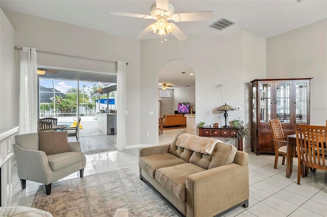 80 Flemingwood Ln, Palm Coast, FL 32137 - living room with ceiling fan, light tile patterned flooring, arched walkways, and baseboards