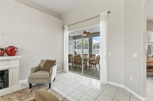 80 Flemingwood Ln, Palm Coast, FL 32137 - sitting room with light tile patterned floors, a glass covered fireplace, baseboards, and ceiling fan