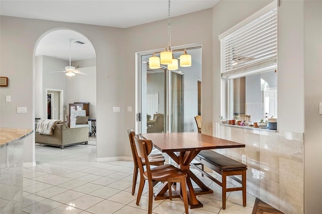 80 Flemingwood Ln, Palm Coast, FL 32137 - dining area featuring arched walkways, ceiling fan, light tile patterned floors, and baseboards
