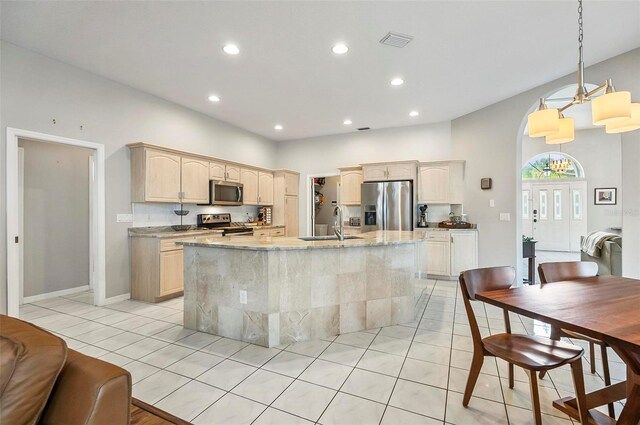 80 Flemingwood Ln, Palm Coast, FL 32137 - kitchen featuring appliances with stainless steel finishes, a sink, light brown cabinets, light tile patterned floors, and an island with sink