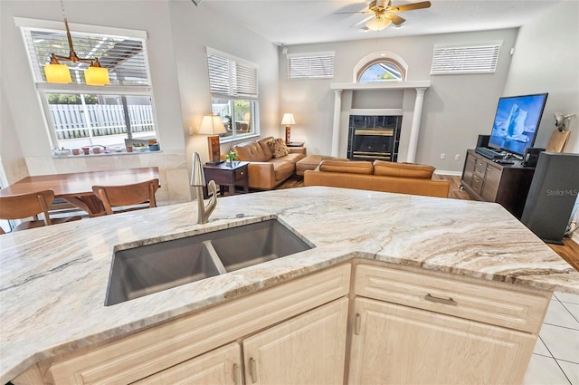 80 Flemingwood Ln, Palm Coast, FL 32137 - kitchen featuring a sink, a ceiling fan, light stone countertops, and a tiled fireplace