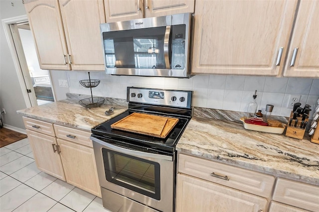 80 Flemingwood Ln, Palm Coast, FL 32137 - kitchen featuring stainless steel appliances, light brown cabinetry, decorative backsplash, and light tile patterned flooring