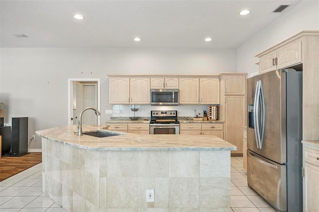 80 Flemingwood Ln, Palm Coast, FL 32137 - kitchen featuring stainless steel appliances, light brown cabinets, a sink, light tile patterned flooring, and a kitchen island with sink