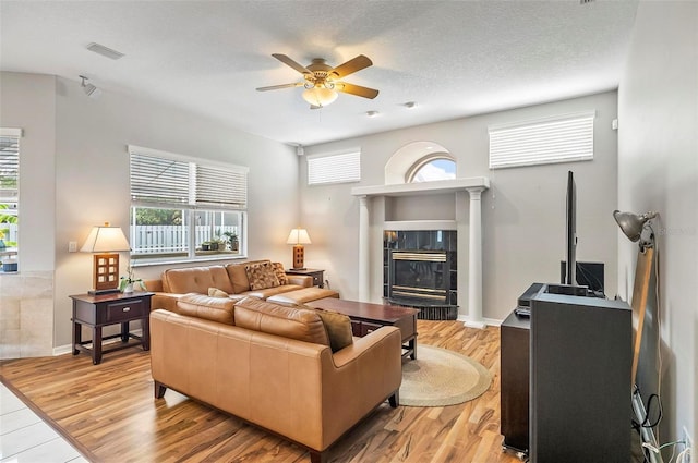 80 Flemingwood Ln, Palm Coast, FL 32137 - living area featuring ceiling fan, healthy amount of natural light, a tiled fireplace, and wood finished floors