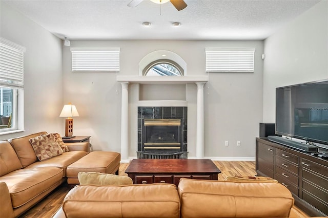 80 Flemingwood Ln, Palm Coast, FL 32137 - living room with a ceiling fan, wood finished floors, a fireplace, healthy amount of natural light, and a textured ceiling