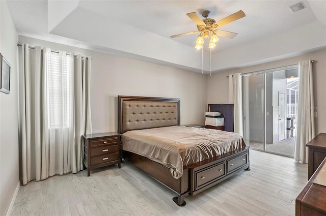 80 Flemingwood Ln, Palm Coast, FL 32137 - bedroom featuring access to outside, light wood-type flooring, multiple windows, and a tray ceiling