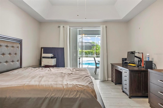 80 Flemingwood Ln, Palm Coast, FL 32137 - bedroom featuring a tray ceiling, access to outside, light wood-type flooring, and a desk