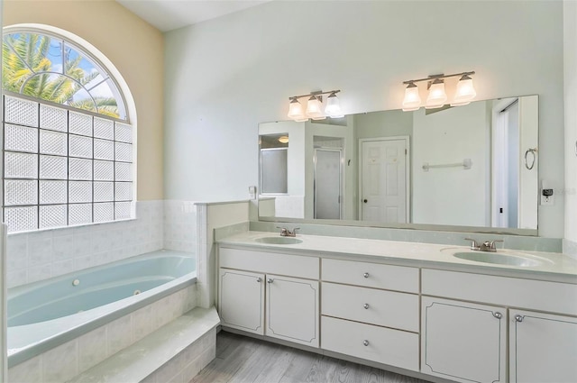 80 Flemingwood Ln, Palm Coast, FL 32137 - bathroom with a garden tub, double vanity, a shower stall, and wood finished floors