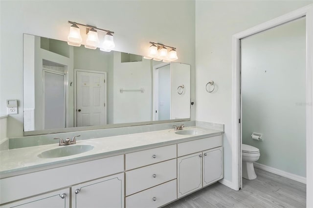 80 Flemingwood Ln, Palm Coast, FL 32137 - bathroom featuring double vanity, toilet, wood finished floors, a shower stall, and baseboards