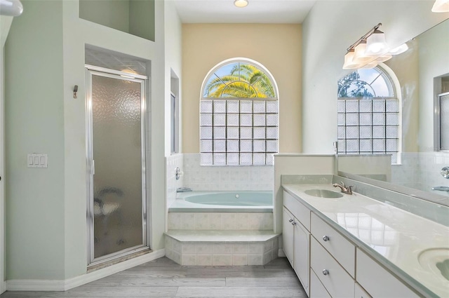 80 Flemingwood Ln, Palm Coast, FL 32137 - bathroom with a stall shower, a garden tub, double vanity, and wood finished floors