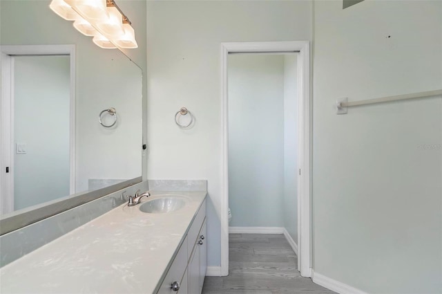 80 Flemingwood Ln, Palm Coast, FL 32137 - bathroom with vanity, toilet, baseboards, and wood finished floors