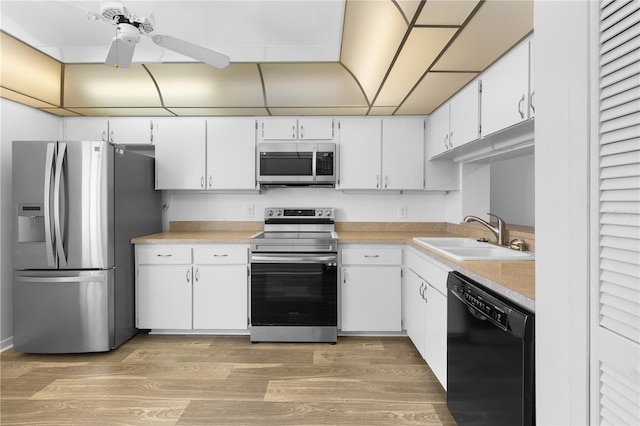 1 Tomoka Oaks Blvd Unit 135, Ormond Beach, FL 32174 - kitchen with appliances with stainless steel finishes, a sink, light countertops, a ceiling fan, and white cabinetry
