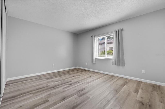 1 Tomoka Oaks Blvd Unit 135, Ormond Beach, FL 32174 - empty room with a textured ceiling, wood finished floors, and baseboards