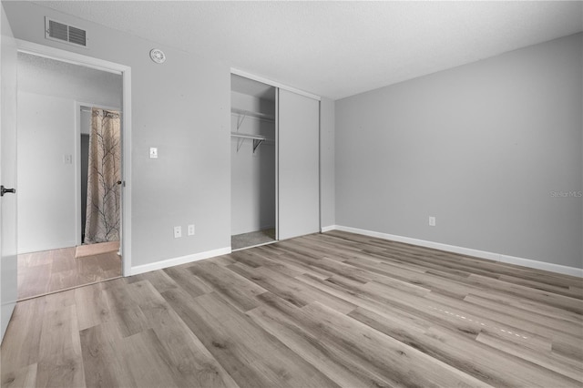 1 Tomoka Oaks Blvd Unit 135, Ormond Beach, FL 32174 - unfurnished bedroom with wood finished floors, a closet, baseboards, and a textured ceiling