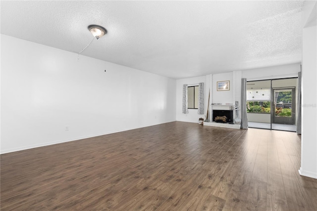 1 Tomoka Oaks Blvd Unit 135, Ormond Beach, FL 32174 - unfurnished living room featuring wood finished floors, a textured ceiling, and a brick fireplace