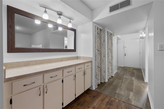 1 Tomoka Oaks Blvd Unit 135, Ormond Beach, FL 32174 - bathroom featuring a textured ceiling, wood finished floors, and vanity
