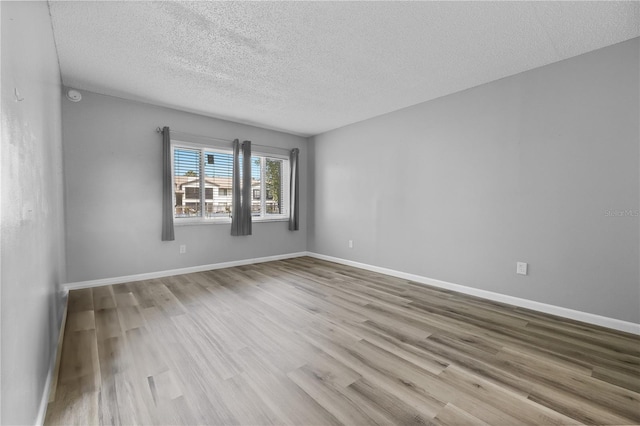 1 Tomoka Oaks Blvd Unit 135, Ormond Beach, FL 32174 - spare room featuring wood finished floors, a textured ceiling, baseboards, and a smoke detector