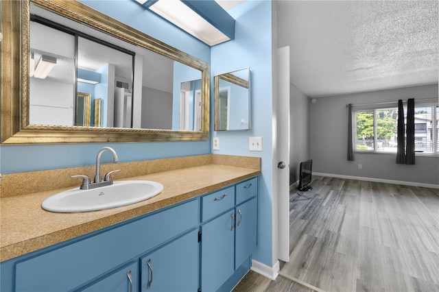 1 Tomoka Oaks Blvd Unit 135, Ormond Beach, FL 32174 - bathroom featuring wood finished floors, a textured ceiling, baseboards, and vanity