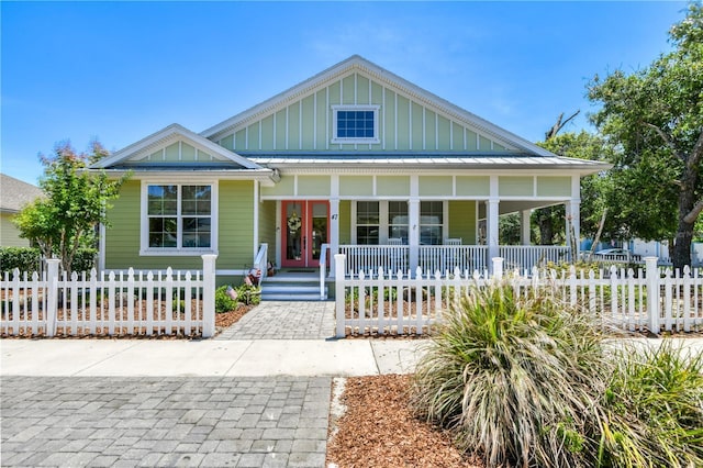 47 Hidden Treasure Dr, Palm Coast, FL 32137 - view of front of property featuring covered porch, board and batten siding, and a fenced front yard