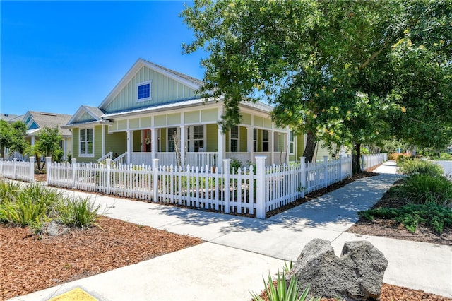 47 Hidden Treasure Dr, Palm Coast, FL 32137 - view of front facade featuring covered porch, board and batten siding, and a fenced front yard