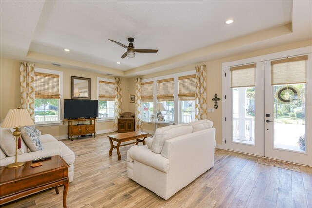47 Hidden Treasure Dr, Palm Coast, FL 32137 - living area featuring a raised ceiling, french doors, a ceiling fan, baseboards, and light wood-type flooring