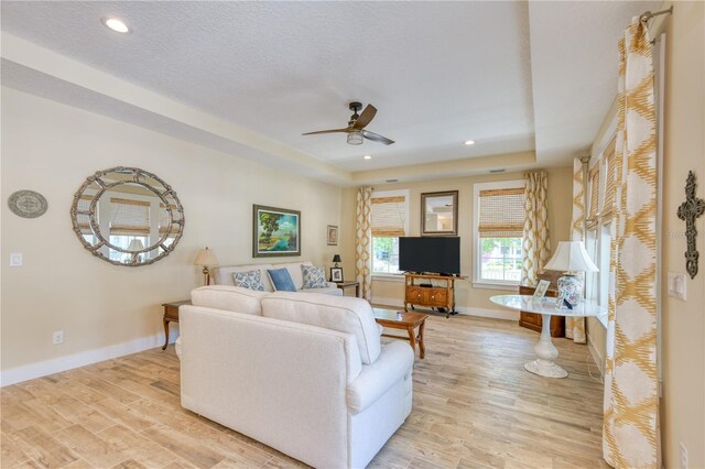 47 Hidden Treasure Dr, Palm Coast, FL 32137 - living area featuring light wood-type flooring, ceiling fan, a tray ceiling, baseboards, and recessed lighting