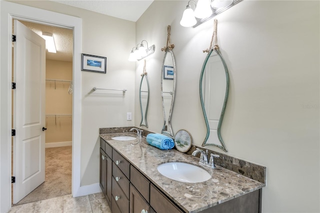 47 Hidden Treasure Dr, Palm Coast, FL 32137 - full bathroom featuring double vanity, baseboards, and a walk in closet