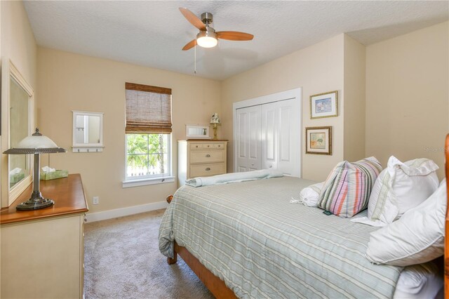 47 Hidden Treasure Dr, Palm Coast, FL 32137 - carpeted bedroom featuring a closet, baseboards, a textured ceiling, and a ceiling fan