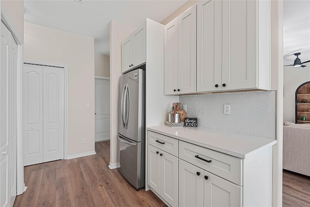8 Zelda Ct, Palm Coast, FL 32164 - kitchen with freestanding refrigerator, wood finished floors, decorative backsplash, light countertops, and baseboards