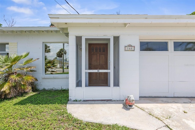 168 Palmetto Ave, Flagler Beach, FL 32136 - view of exterior entry featuring concrete block siding and a garage