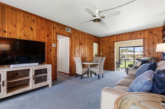 168 Palmetto Ave, Flagler Beach, FL 32136 - living area with wood walls, carpet flooring, ornamental molding, and a ceiling fan