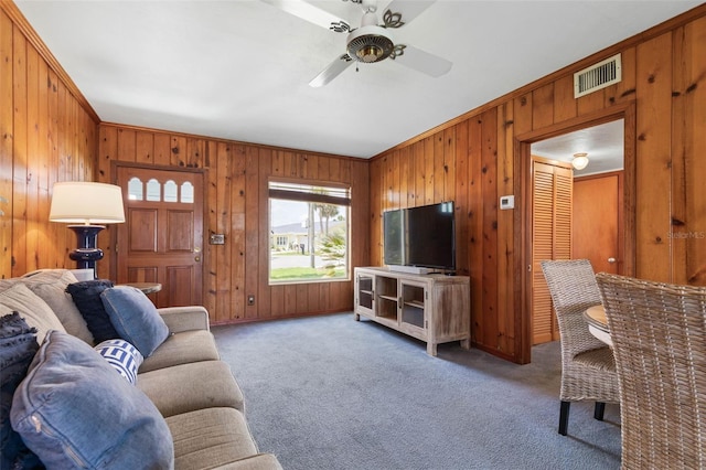 168 Palmetto Ave, Flagler Beach, FL 32136 - carpeted living area featuring wooden walls, crown molding, and a ceiling fan