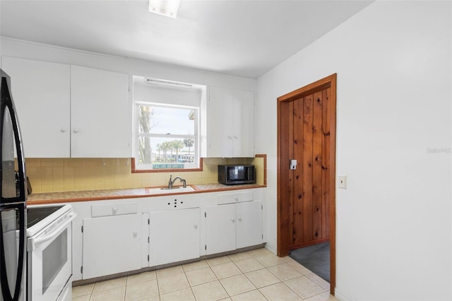168 Palmetto Ave, Flagler Beach, FL 32136 - kitchen featuring white cabinets, backsplash, a sink, electric stove, and black microwave