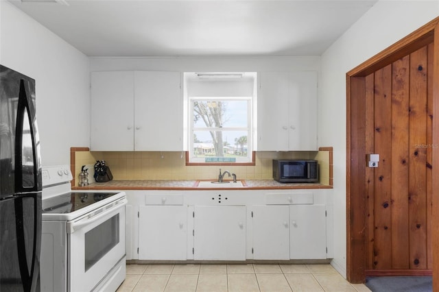 168 Palmetto Ave, Flagler Beach, FL 32136 - kitchen featuring black appliances, white cabinets, backsplash, tile countertops, and a sink