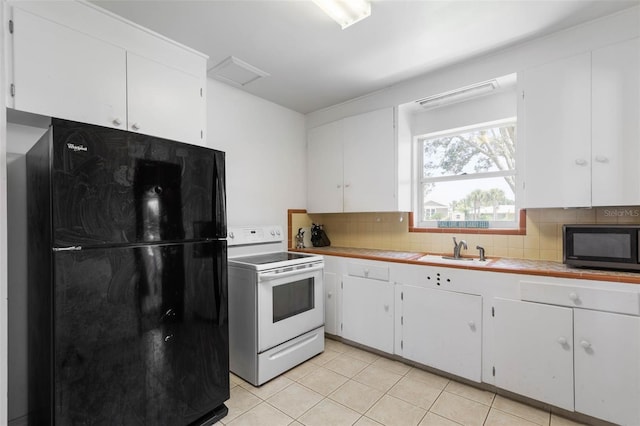 168 Palmetto Ave, Flagler Beach, FL 32136 - kitchen featuring black appliances, a sink, and white cabinetry