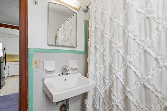168 Palmetto Ave, Flagler Beach, FL 32136 - full bath featuring tile walls, a sink, wainscoting, a shower with curtain, and tile patterned flooring