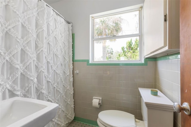 168 Palmetto Ave, Flagler Beach, FL 32136 - bathroom with tile walls, toilet, wainscoting, tile patterned floors, and curtained shower