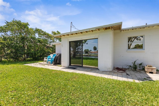 168 Palmetto Ave, Flagler Beach, FL 32136 - back of property featuring concrete block siding, a yard, and a patio area