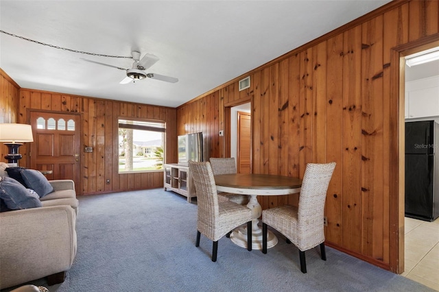 168 Palmetto Ave, Flagler Beach, FL 32136 - dining space featuring wooden walls, a ceiling fan, light colored carpet, and ornamental molding