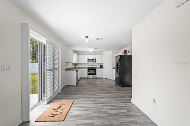 6 Ryding Ln, Palm Coast, FL 32164 - kitchen with appliances with stainless steel finishes, light wood-style floors, white cabinets, and baseboards