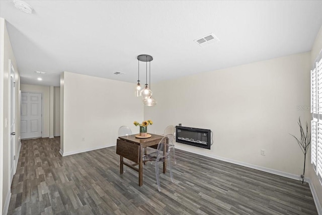 6 Ryding Ln, Palm Coast, FL 32164 - dining area with dark wood-style flooring, baseboards, and a glass covered fireplace