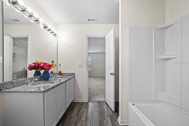 6 Ryding Ln, Palm Coast, FL 32164 - full bathroom featuring wood finished floors, double vanity, a textured ceiling, shower / washtub combination, and baseboards