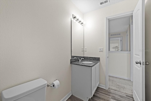 6 Ryding Ln, Palm Coast, FL 32164 - bathroom with wood finished floors, vanity, toilet, and baseboards