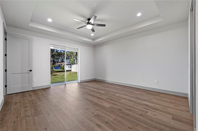 11 Ethan Allen Dr, Palm Coast, FL 32164 - empty room featuring a raised ceiling, a ceiling fan, wood finished floors, and recessed lighting