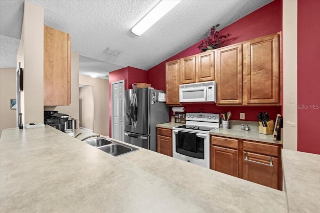 33 Bud Field Dr, Palm Coast, FL 32137 - kitchen featuring white appliances, a sink, a textured ceiling, light countertops, and brown cabinetry