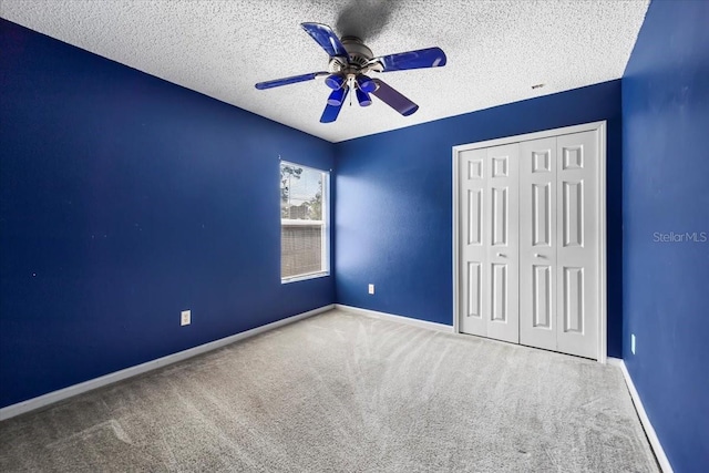33 Bud Field Dr, Palm Coast, FL 32137 - unfurnished bedroom featuring carpet, a closet, a textured ceiling, baseboards, and a ceiling fan